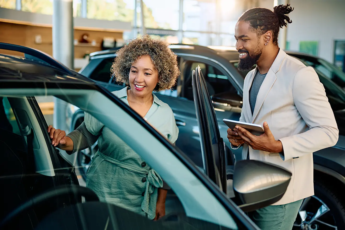 Cliente satisfeito comprando um carro novo com o vendedor no showroom