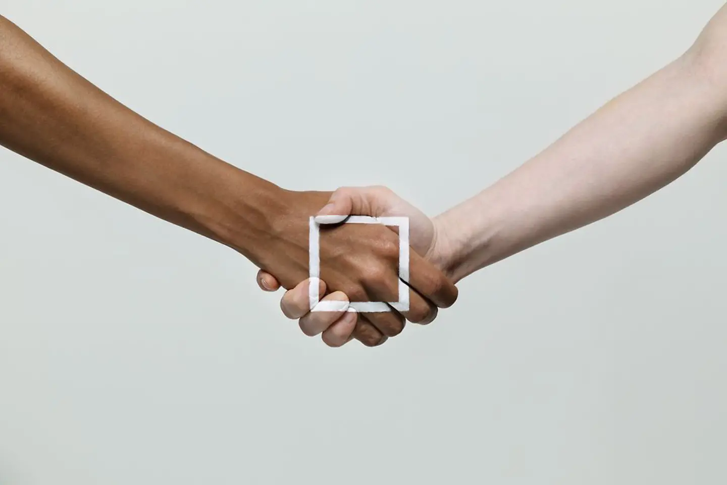 Two shaking hands with a white square drawn on them