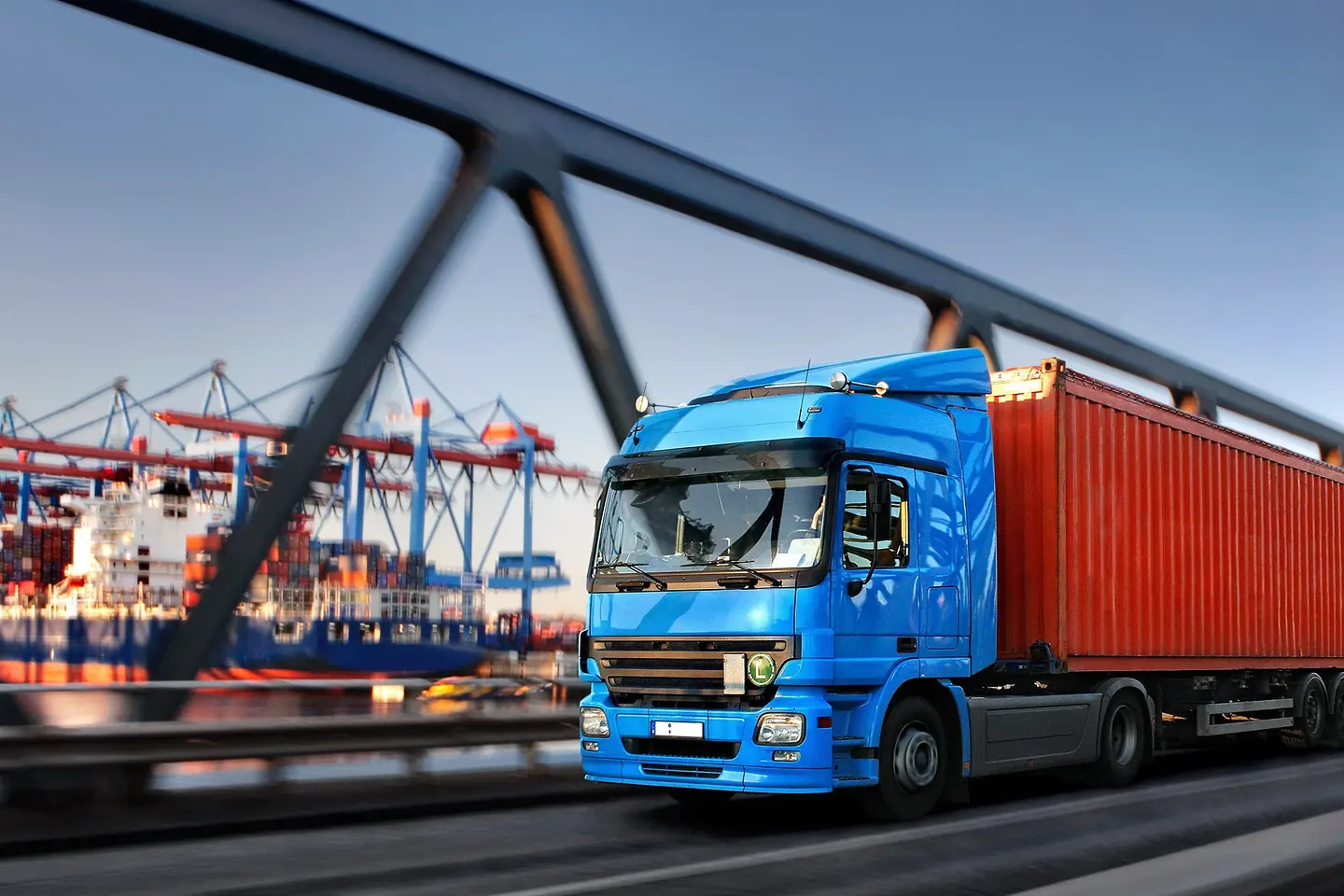 Vrachtwagen op een brug met haven op de achtergrond
