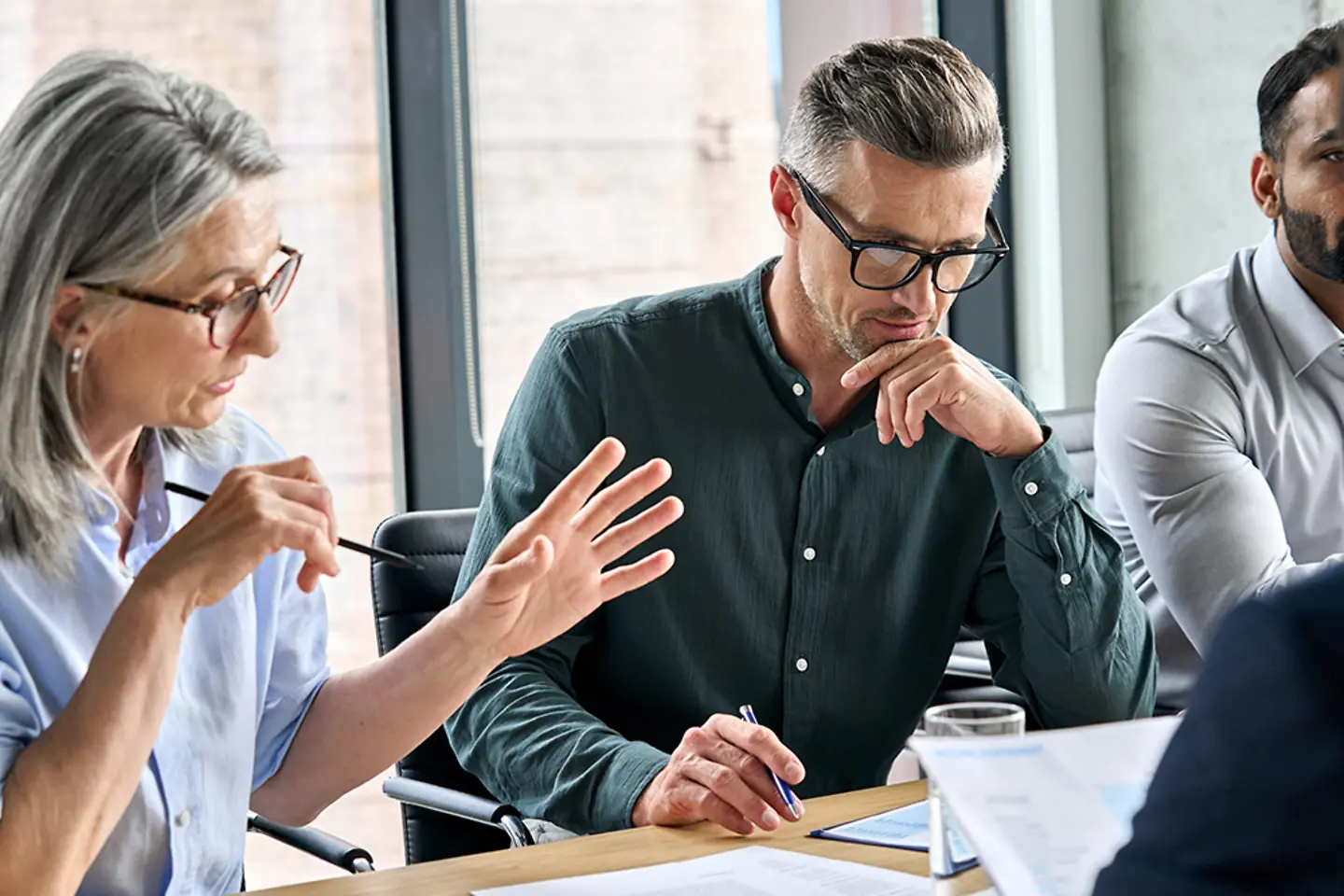 Coworkers discussing in a modern office setting.