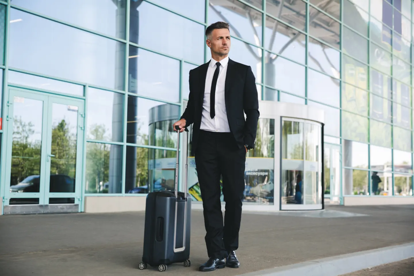 Self-confident, mature businessman stands in front of the airport 