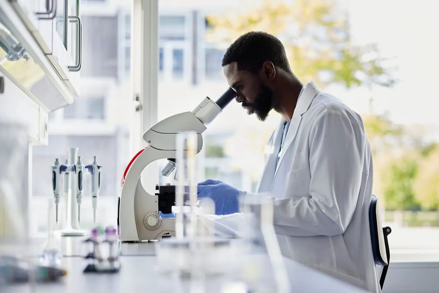 Chemist examines new formula under microscope