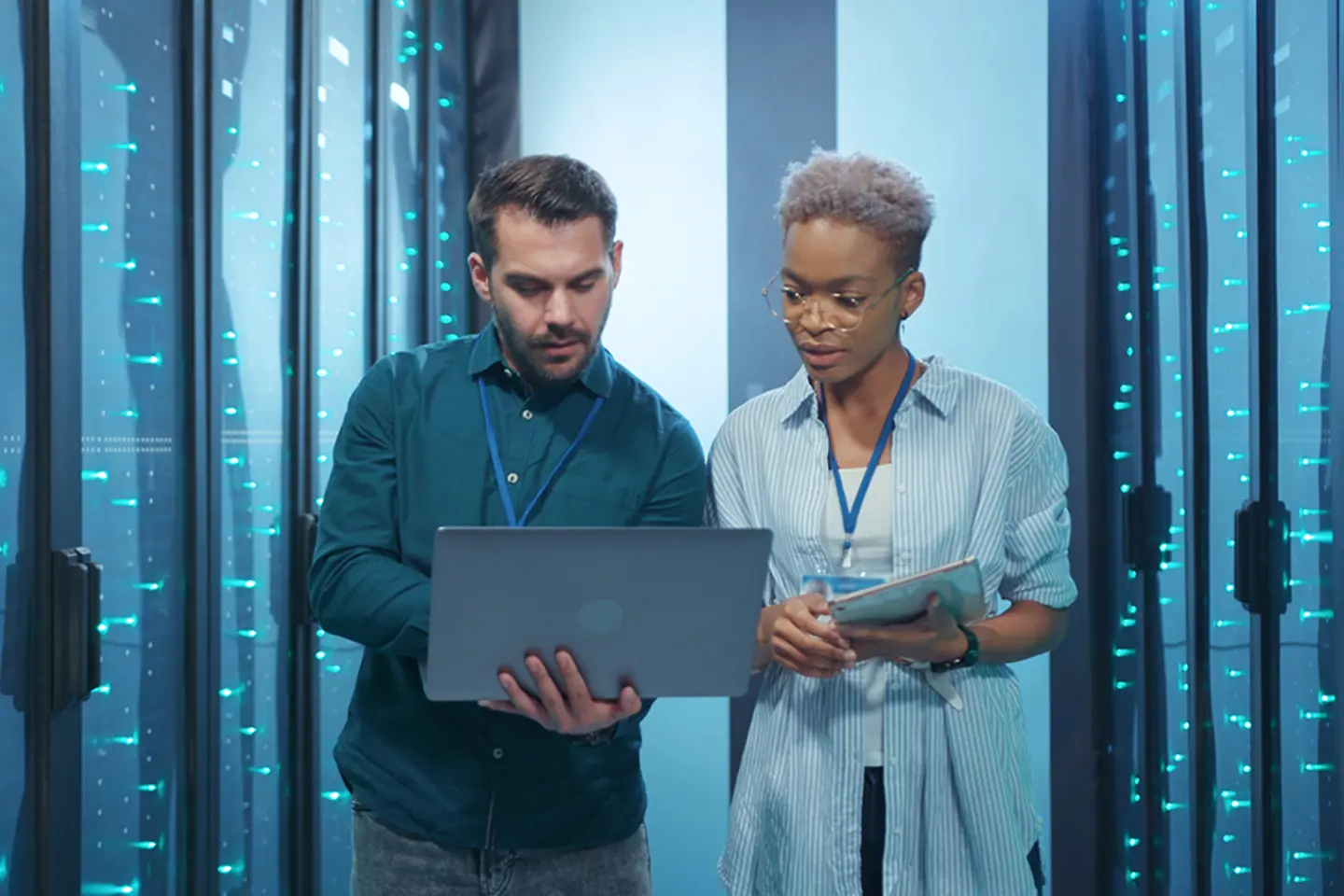 Dois especialistas em nuvem verificam os dados em um tablet no data center