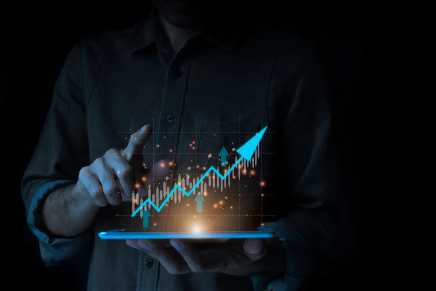 Person holds tablet and points to a diagram with an upward arrow projected on it.
