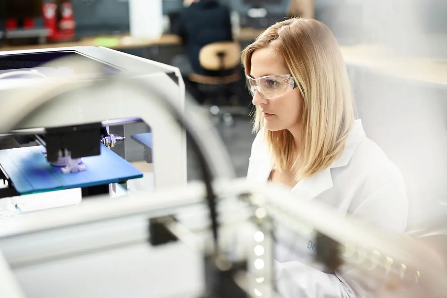 Female technician checking 3D printer