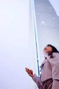 Female customer using cloud on mobile phone in front of building